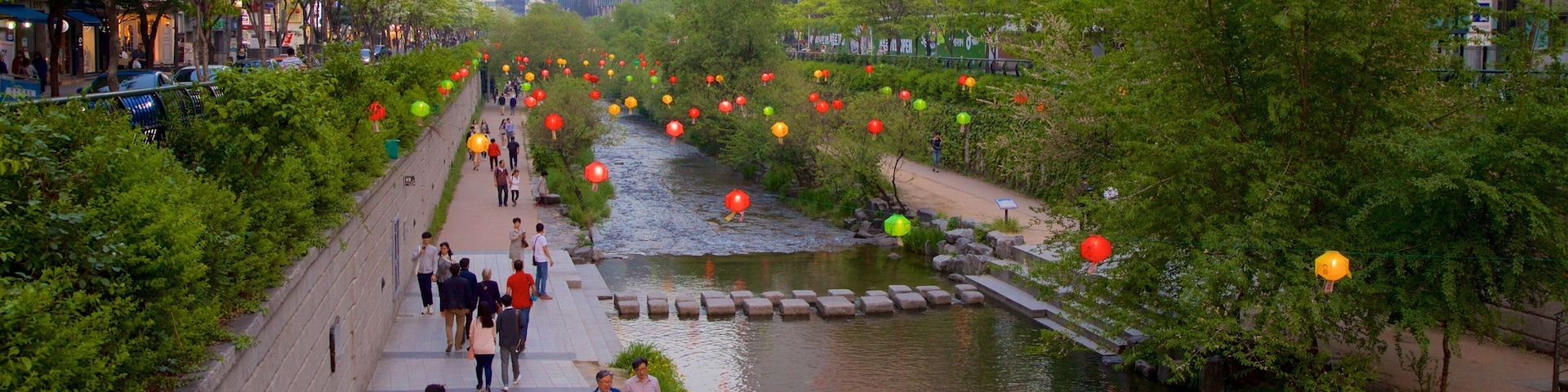 Cheonggyecheon showing a city and a river or creek as well as a small group of people