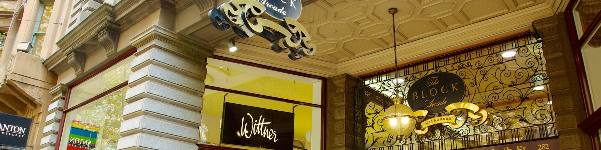 Une rue animée bordée de boutiques, notamment « The Block Arcade » et « Witmer ».