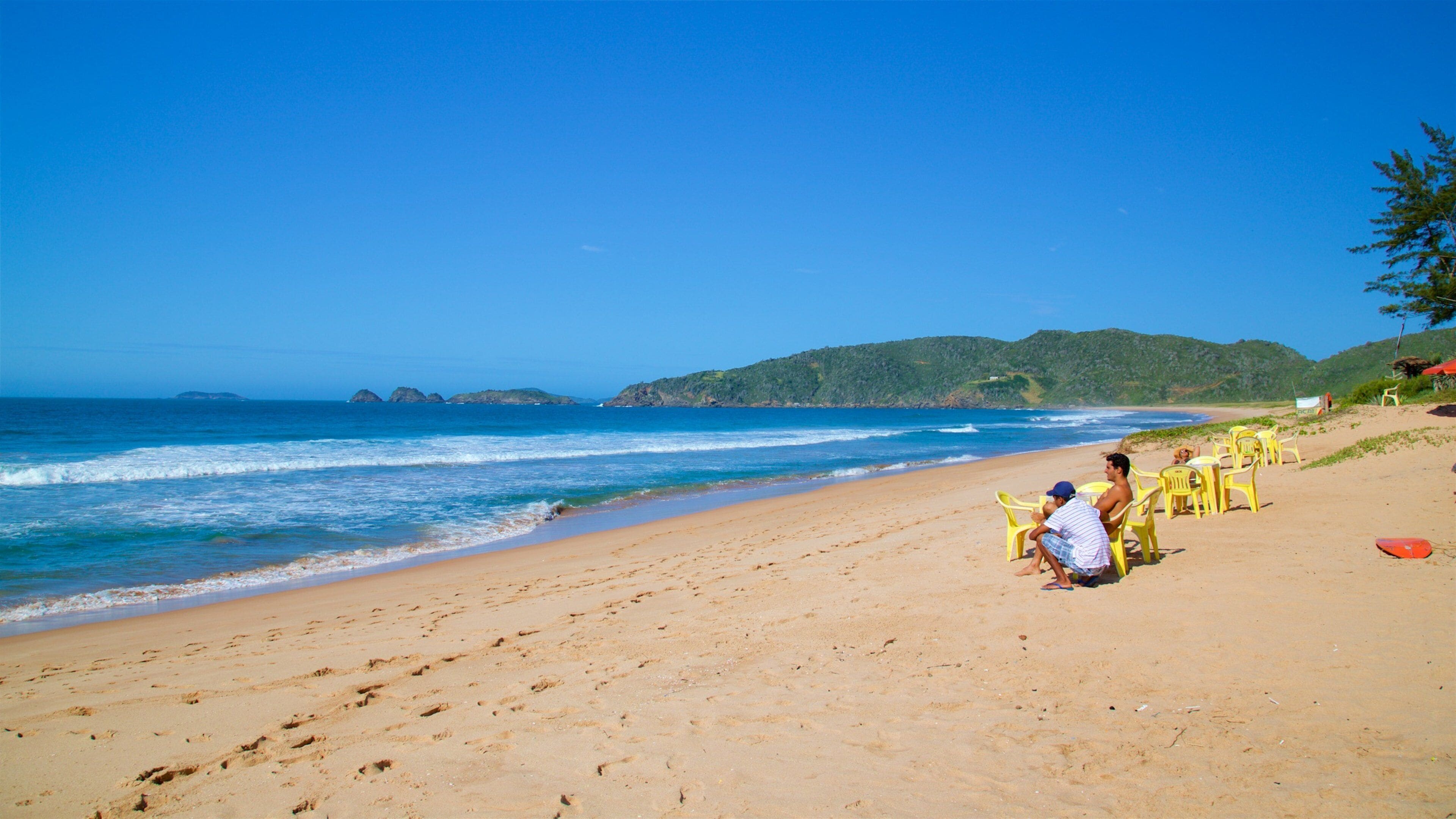 Tucuns Beach showing general coastal views and a sandy beach as well as a small group of people
