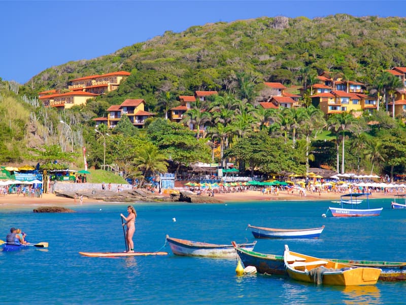 A coastal town with colorful buildings, a beach, and several boats in the water.