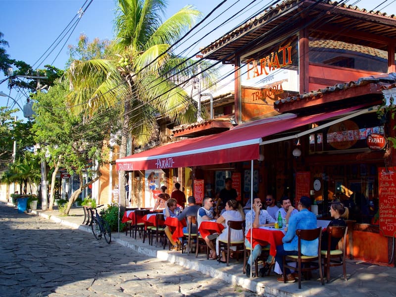 A cobblestone street lined with outdoor seating at a restaurant named Parvati.