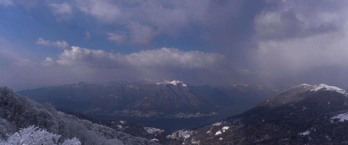 A snow-covered mountain range with a lake in the valley.