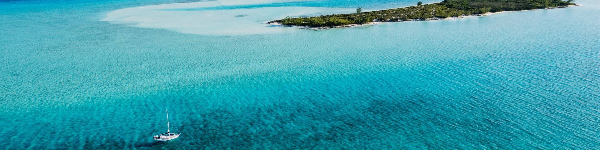 Aerial of Sailboat Next to Island in Turquoise Bahamas Water