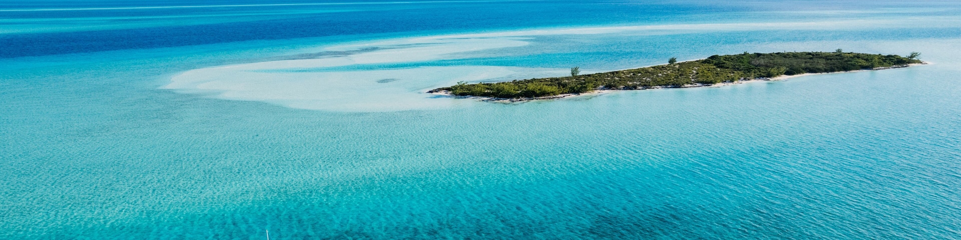 Aerial of Sailboat Next to Island in Turquoise Bahamas Water