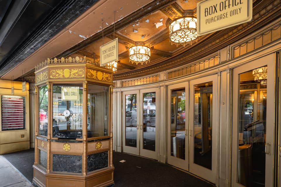 Bilheteria com detalhes dourados ornamentais e um letreiro que diz 'Box Office'.