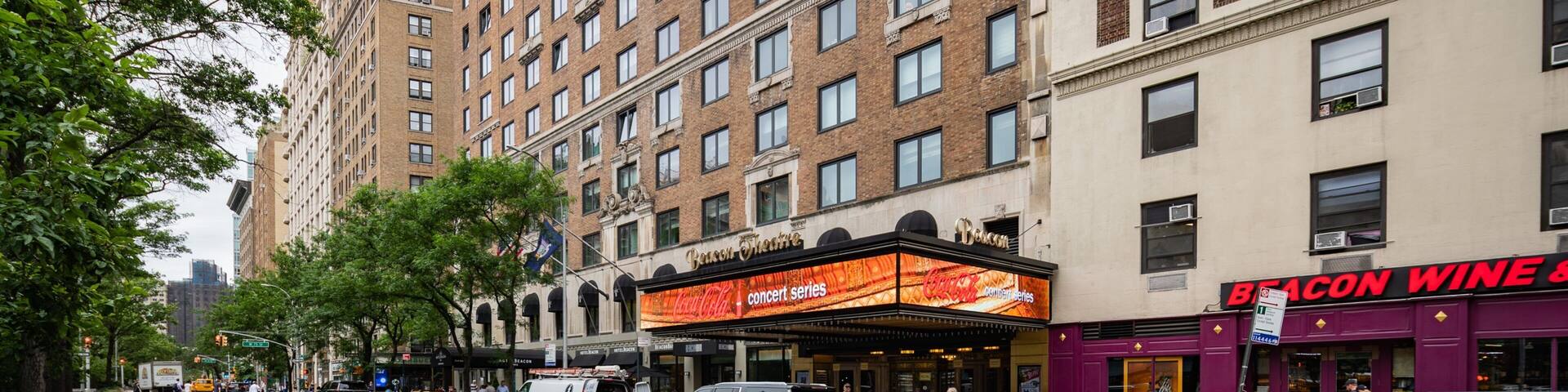 A city street lined with tall buildings, a theater marquee, and a restaurant.