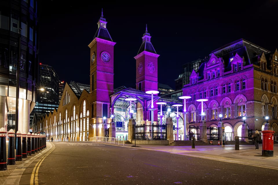 A historic building with clock towers and arched windows at night.