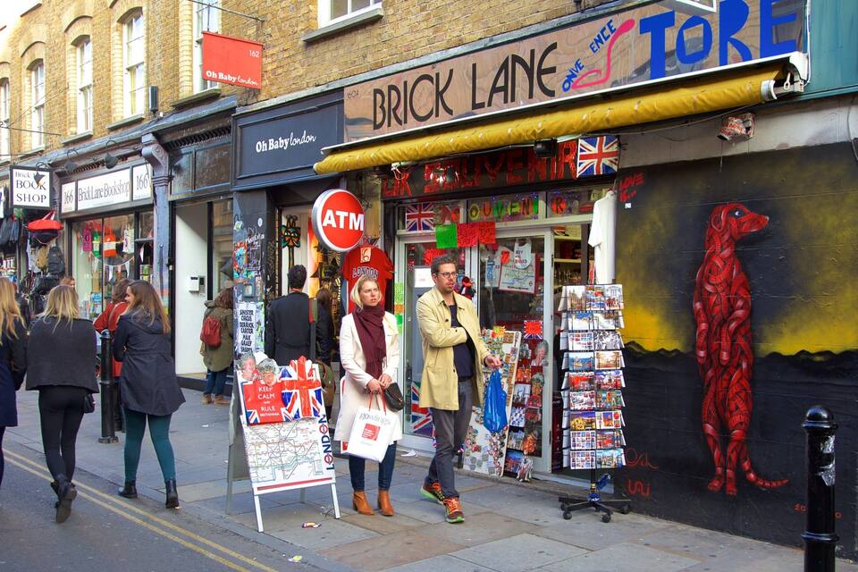 A street with shops, including Brick Lane Bookshop and Oh Baby London.