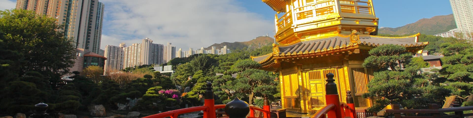 Beautiful golden pavilion surrounded by lush greenery in Eastern Kowloon, Hong Kong, with modern buildings in the background