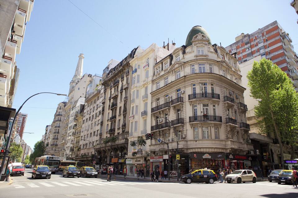A busy urban street with historic buildings, a tram, and pedestrians.