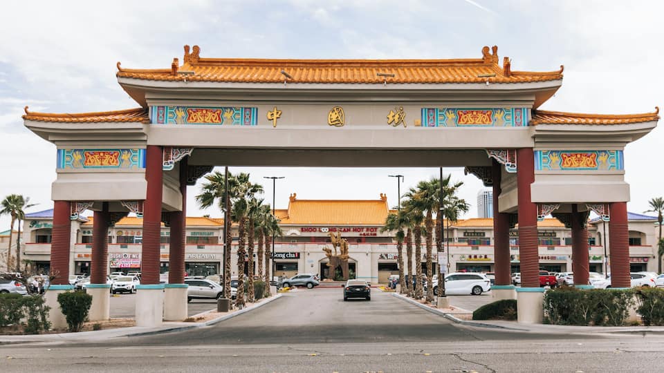 A traditional Chinese gate with ornate decorations and a sign for a hot pot restaurant.