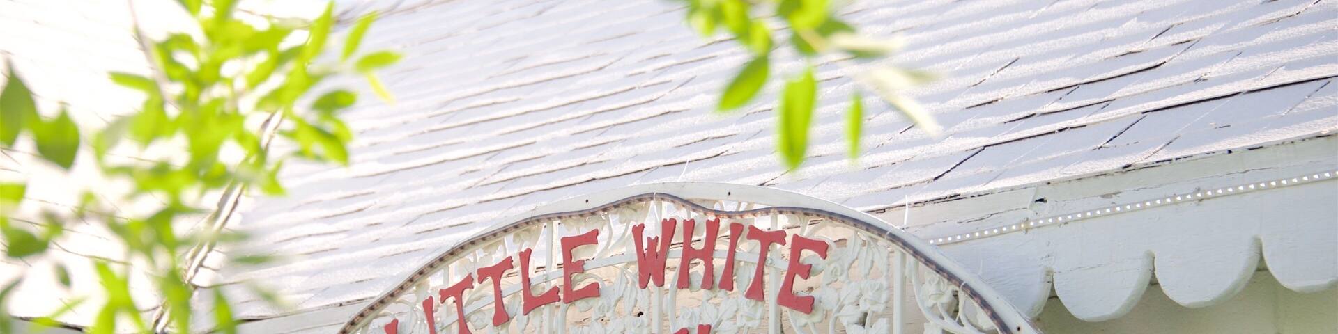 A white building with a sign that reads "Little White Chapel."