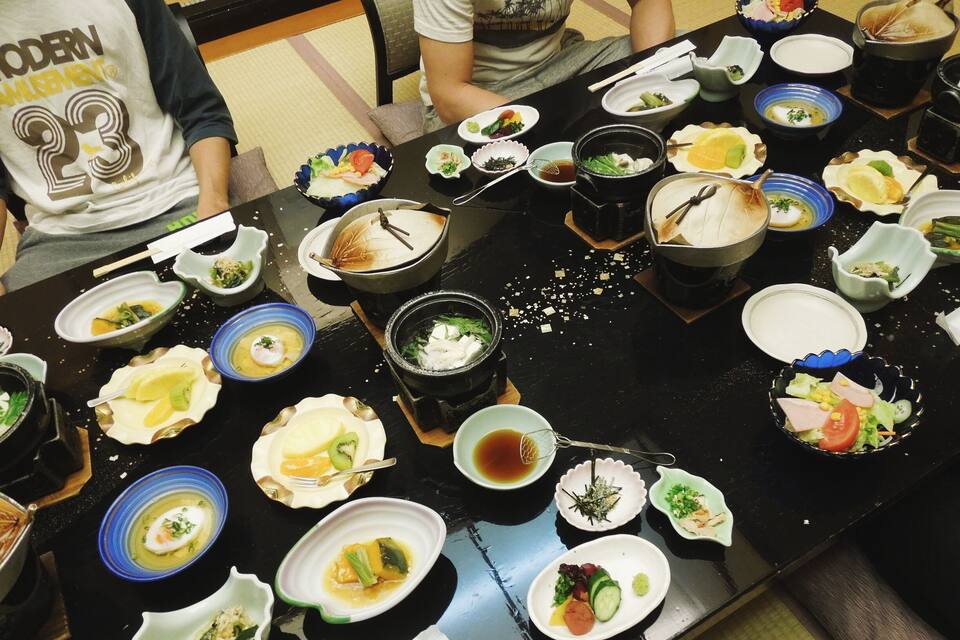 A table with various dishes, including seafood and vegetables, arranged for a meal.