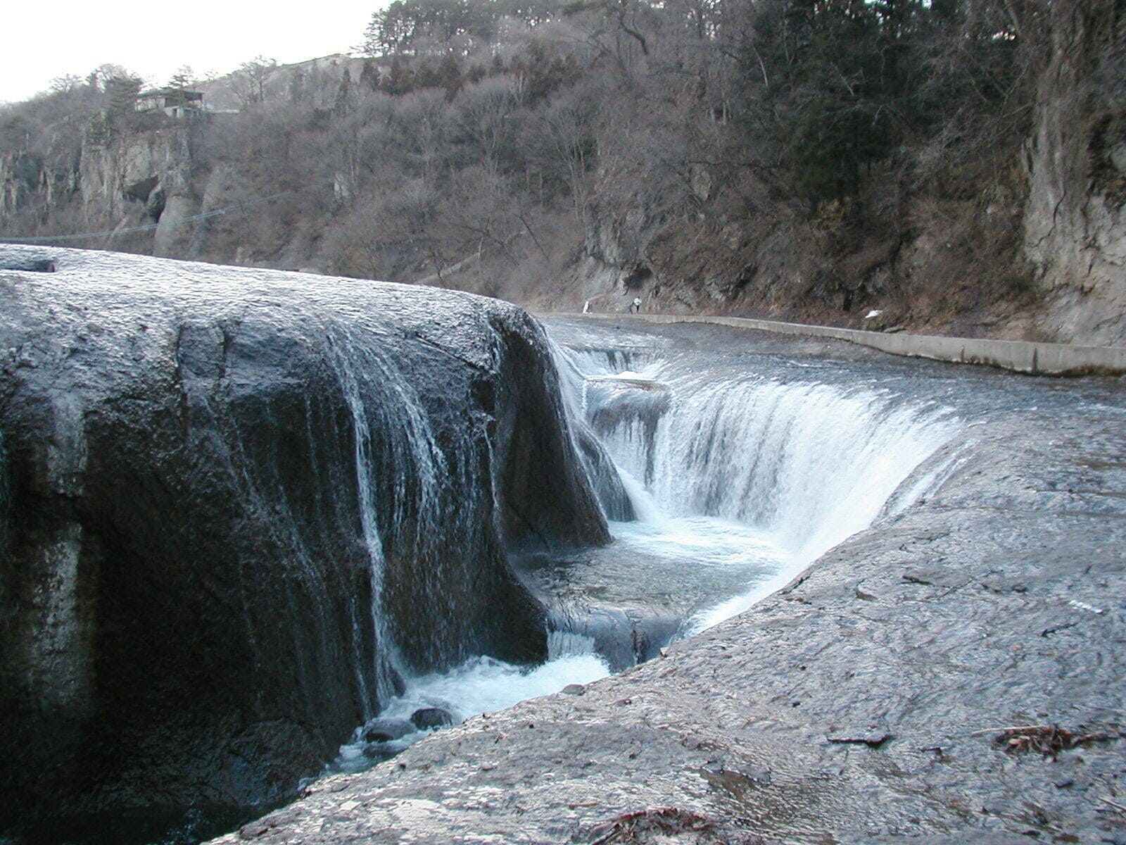 A waterfall cascading over a rocky ledge into a river.