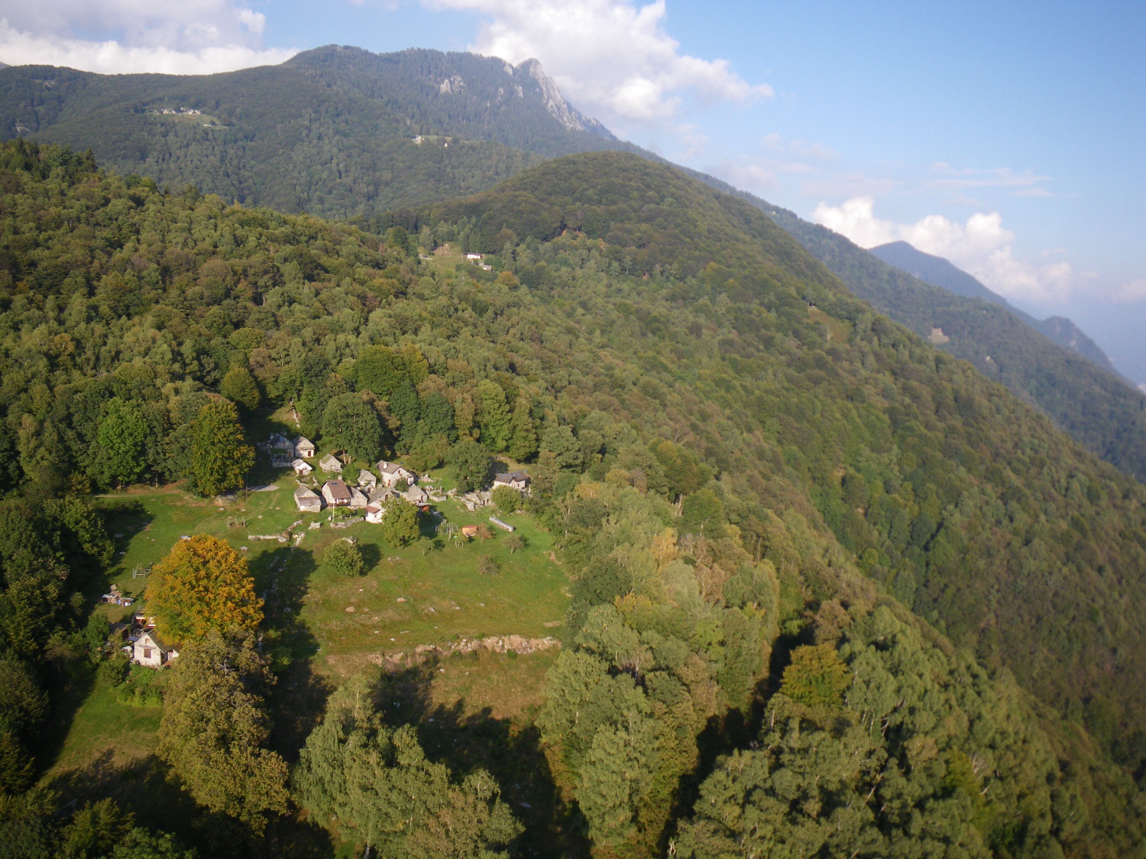A mountainous landscape with a small village nestled among dense forests.