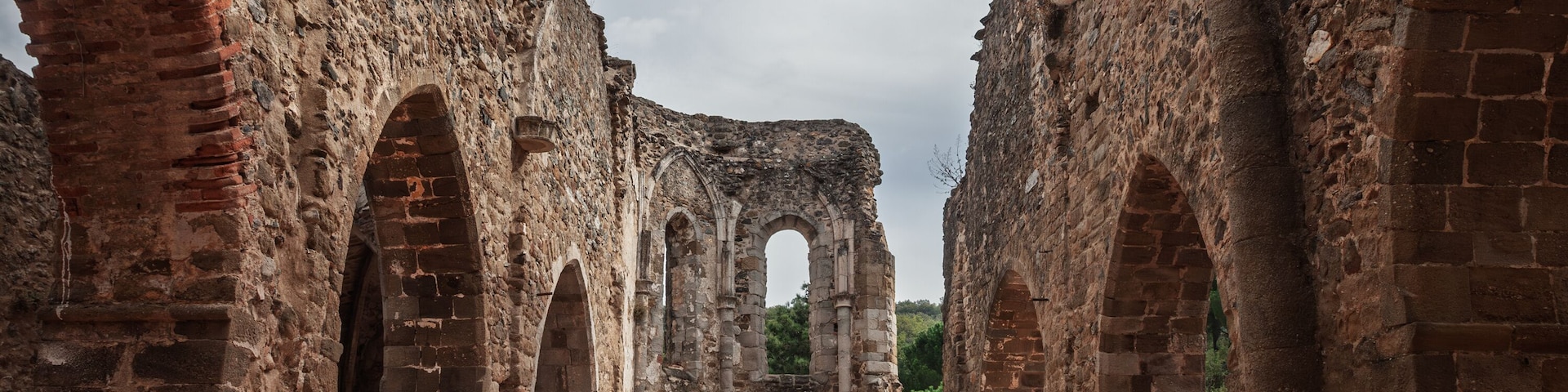 The ruins of the Old Saint-Pons Church, Ancienne Eglise Saint-Pons, in Collobrieres, France, showing stone arches, weathered walls and the open interior of the abandoned monument in Provence.