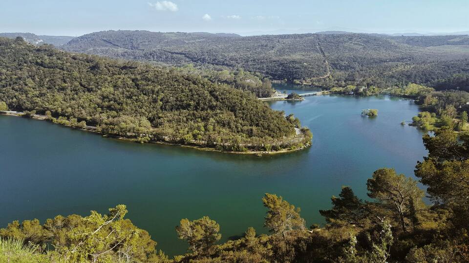 A lake surrounded by dense forest and hills.