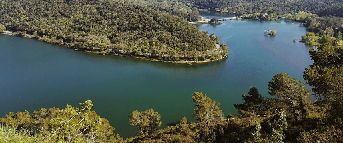 A lake surrounded by dense forest and hills.