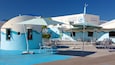 A blue-themed outdoor seating area with umbrellas and chairs in front of a building labeled "Clearwater Marine Aquarium".