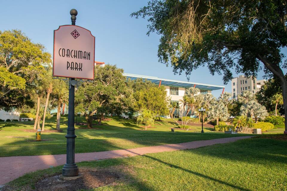 Señal de Coachman Park con un edificio moderno al fondo.
