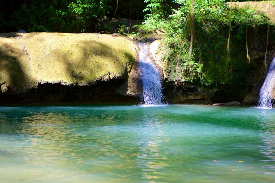 A waterfall cascading over moss-covered rocks into a clear pool.