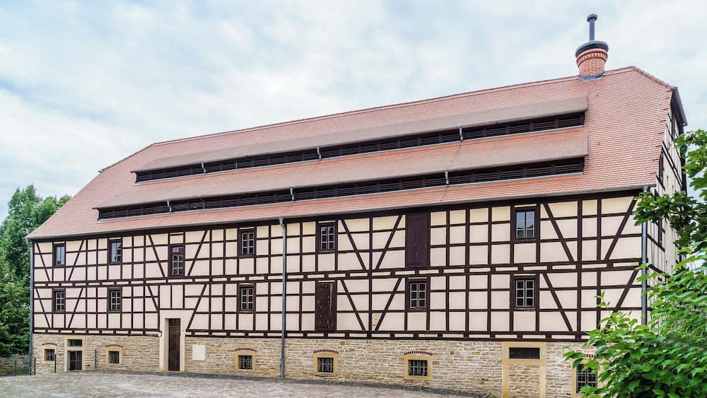 Ein traditionelles Fachwerkhäuschen mit Ziegeldach und Steinuntergrund.