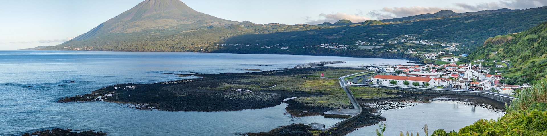 Panoramic view of Fishing village Lajes do Pico with Volcano Mount Pico in background in morning light, Pico Island - Azores