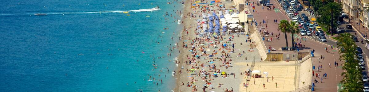 Une plage bondée, une mer d’un bleu limpide, un ballon rouge et une promenade animée bordée d’immeubles.