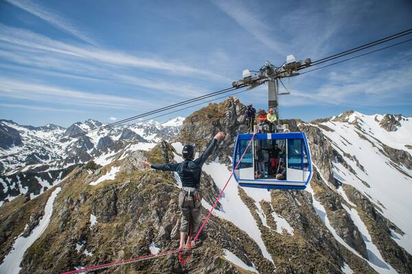 a group of people have installed two cable between cars of the pic du midi and a man walk on it, Occitanie, Bagnères-de-Bigorre, France