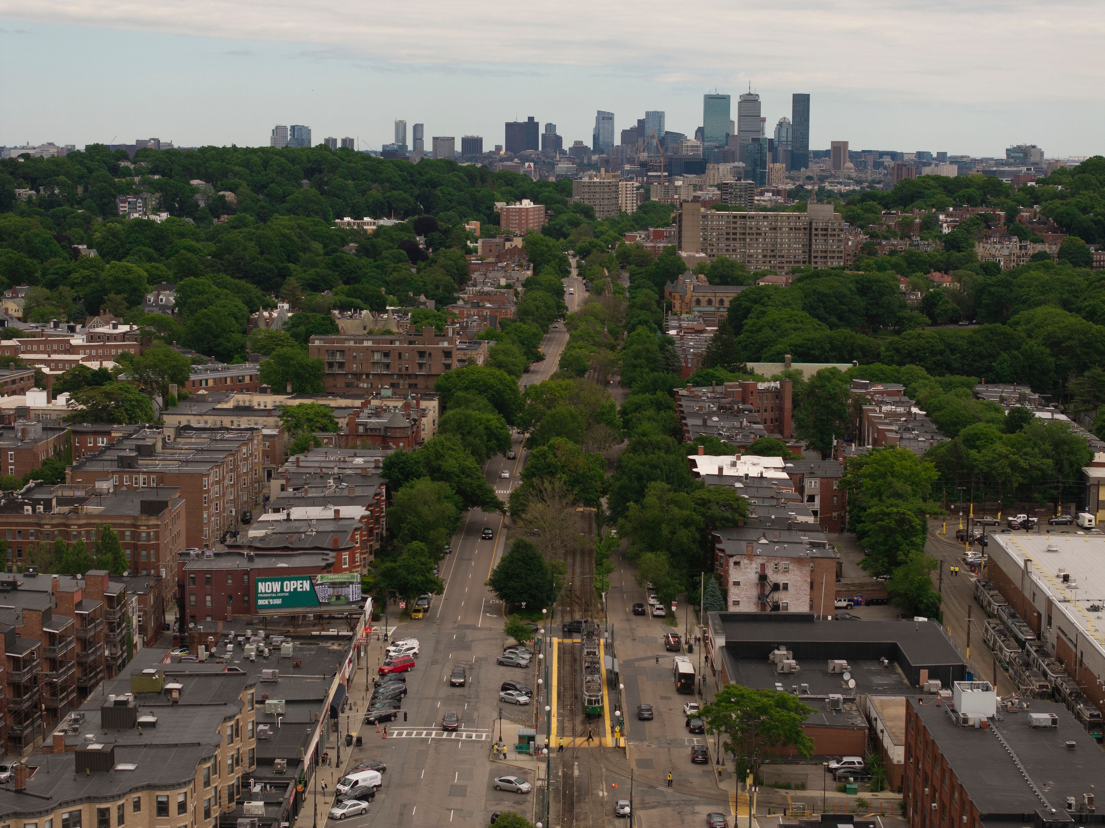 A cityscape with a dense urban area, a central road, and a distant skyline with high-rise buildings.