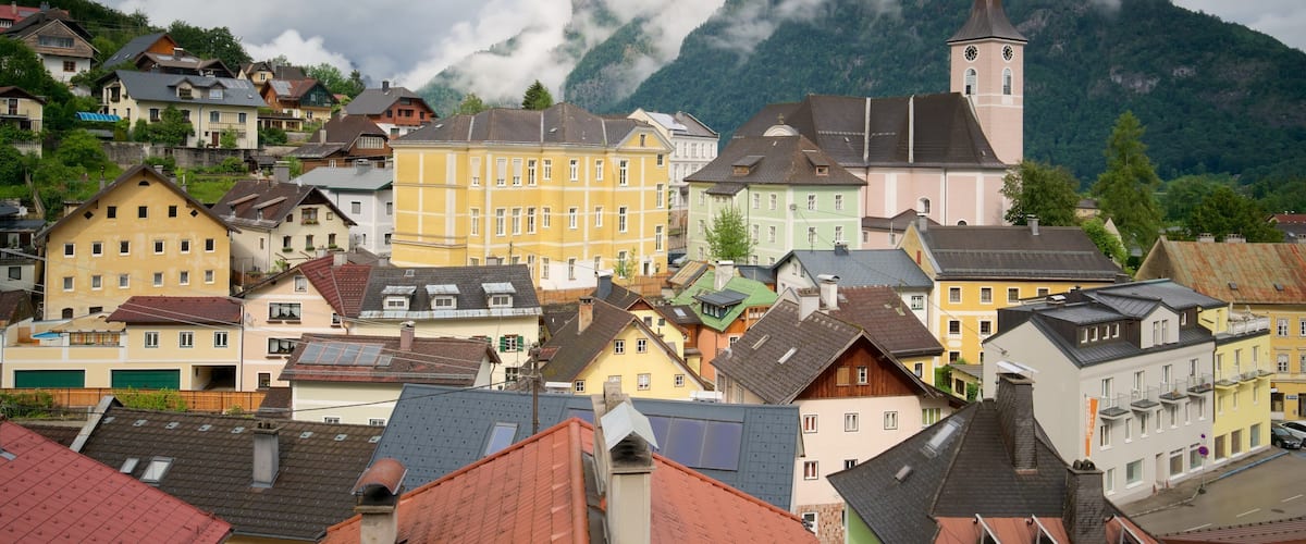 A colorful village with a church and mountains in the background.