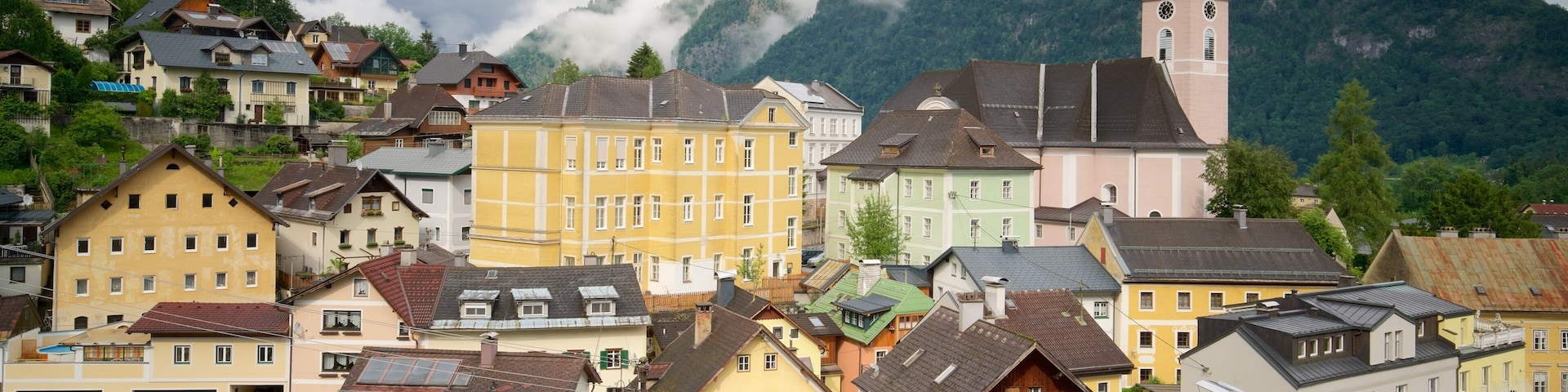 A colorful village with a church and mountains in the background.