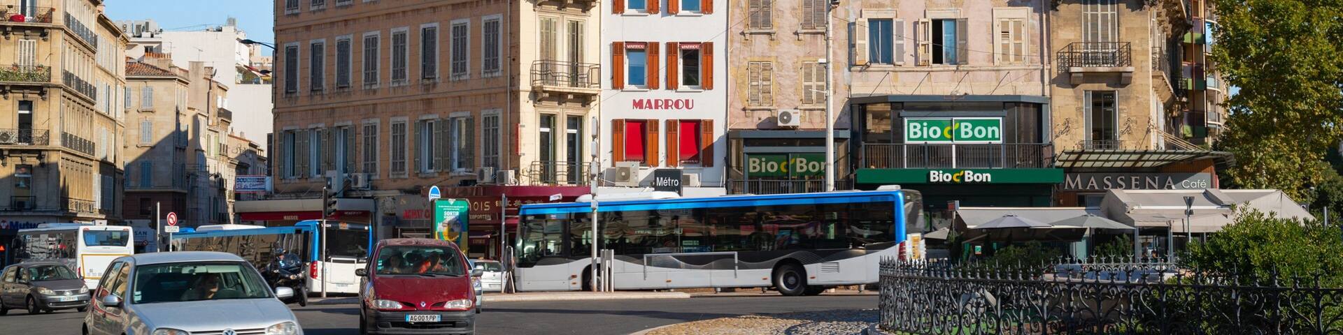 A busy urban street with vintage buildings, a bus, and cars.