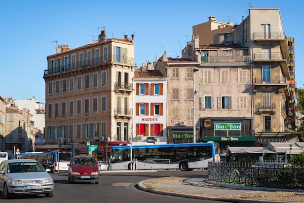 A busy urban street with vintage buildings, a bus, and cars.