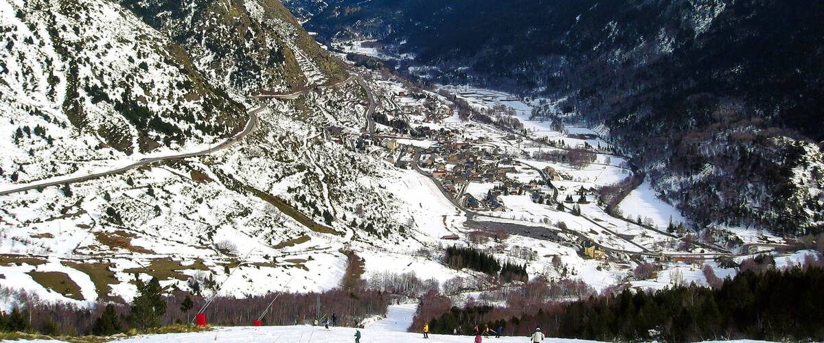 A snow-covered mountain landscape with a town nestled in the valley.