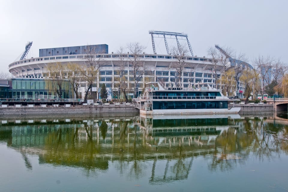 Un estadio grande con un barco fondeado frente a él.
