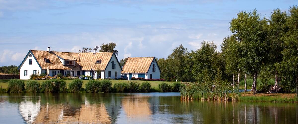 A house by a lake with a reflection.