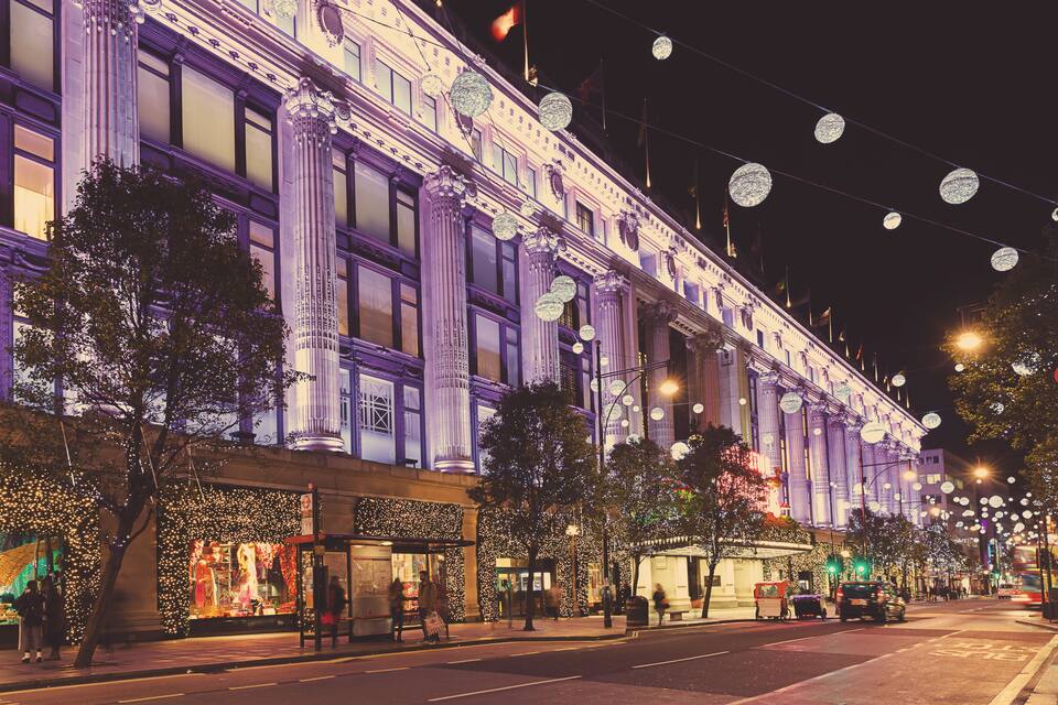 Un edificio imponente con columnas ornamentales y guirnaldas de luces.