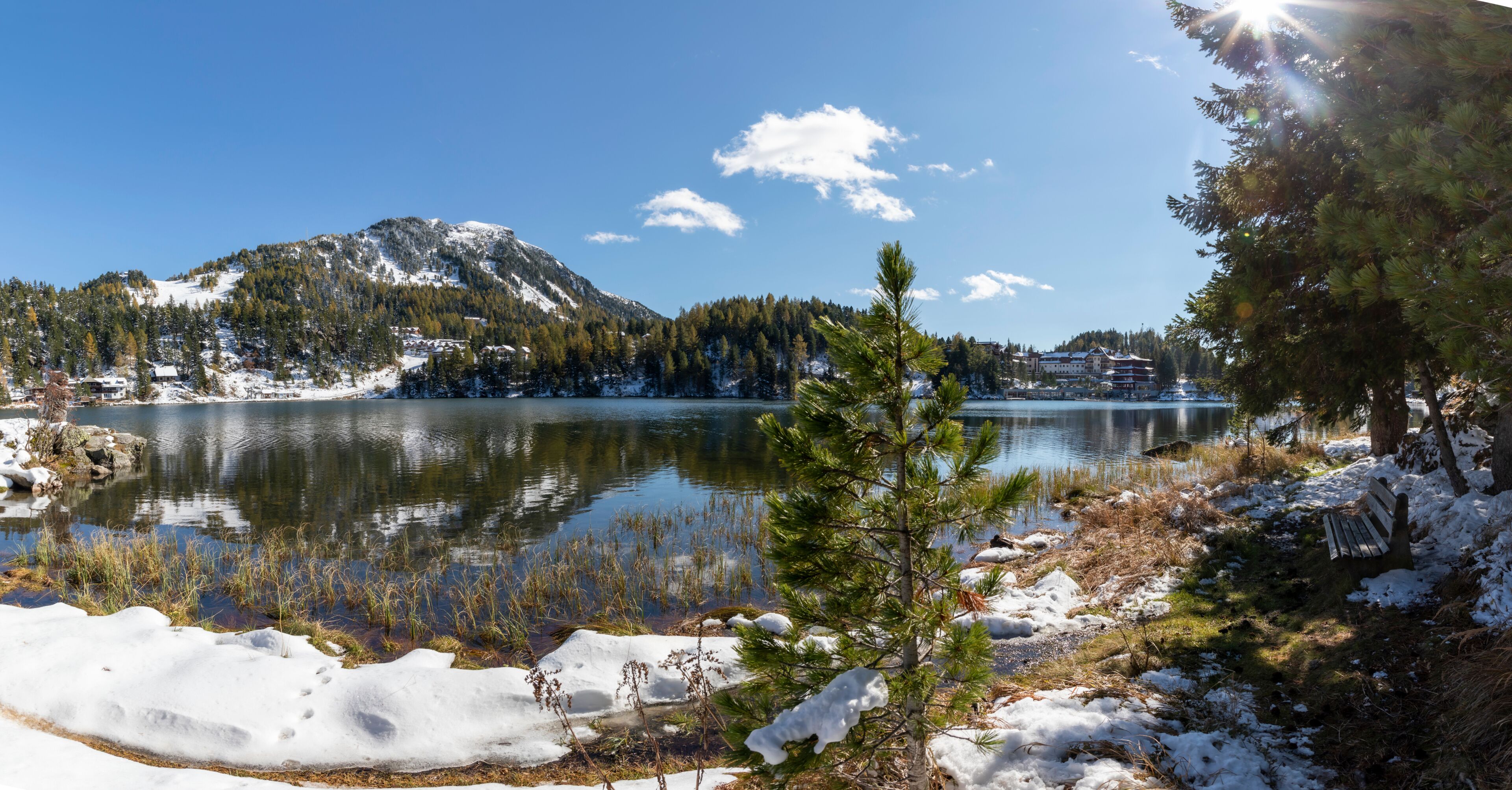 A snow-covered lake with mountains in the background and a clear sky.