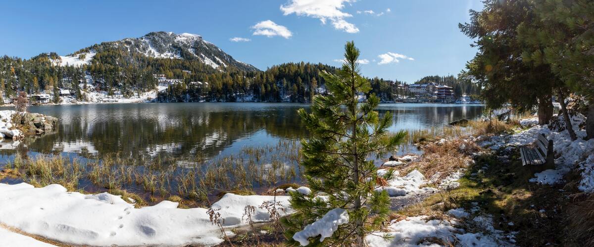 A snow-covered lake with mountains in the background and a clear sky.