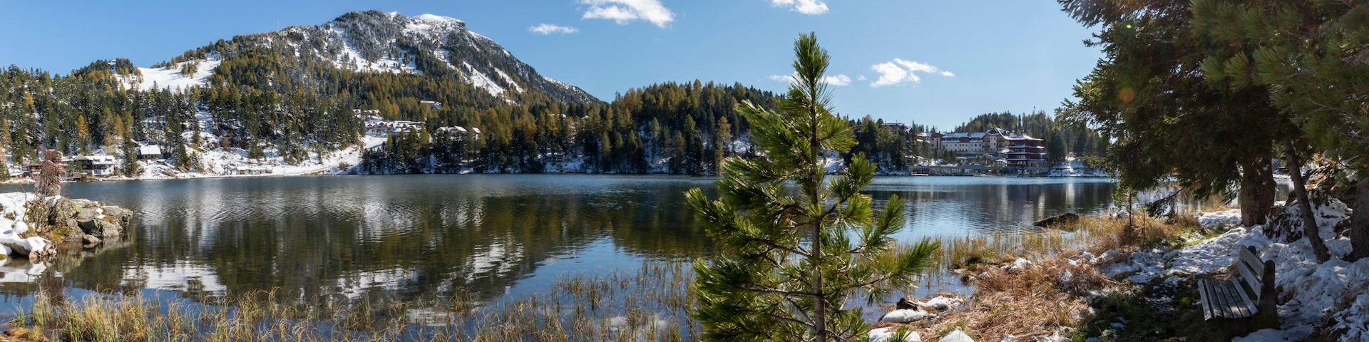 A snow-covered lake with mountains in the background and a clear sky.