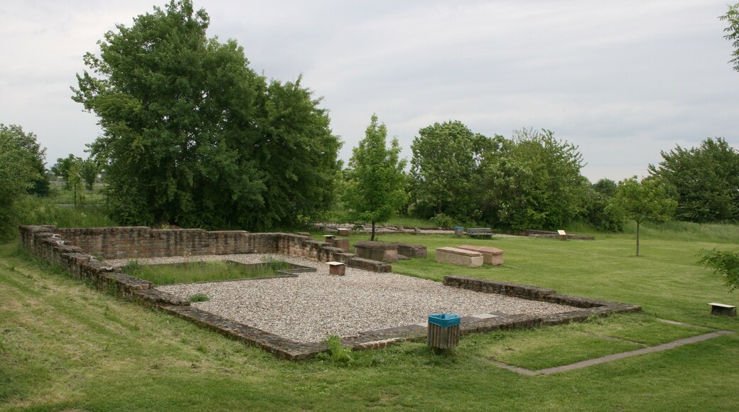 Römische Villa Wachenheim, Ansicht zweier Nebengebäude von Nordwesten. Im Vordergrund Speichergebäude D (mit Darre links und Räucherofen einer früheren Bauphase), im Hintergrund Stallgebäude B mit Wohntrakt C und Kanalheizung. Dazwischen spätantike Steinsarkophage.