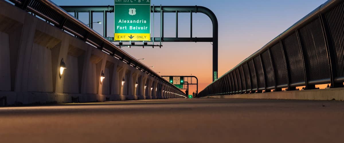 A highway with a green exit sign for Alexandria and Fort Belvoir.