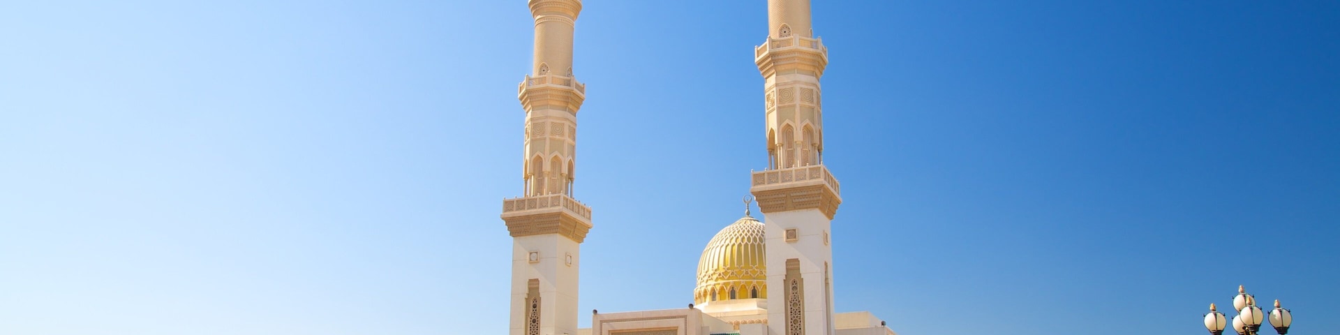 Uma mesquita com dois minaretes altos e uma grande cúpula dourada.
