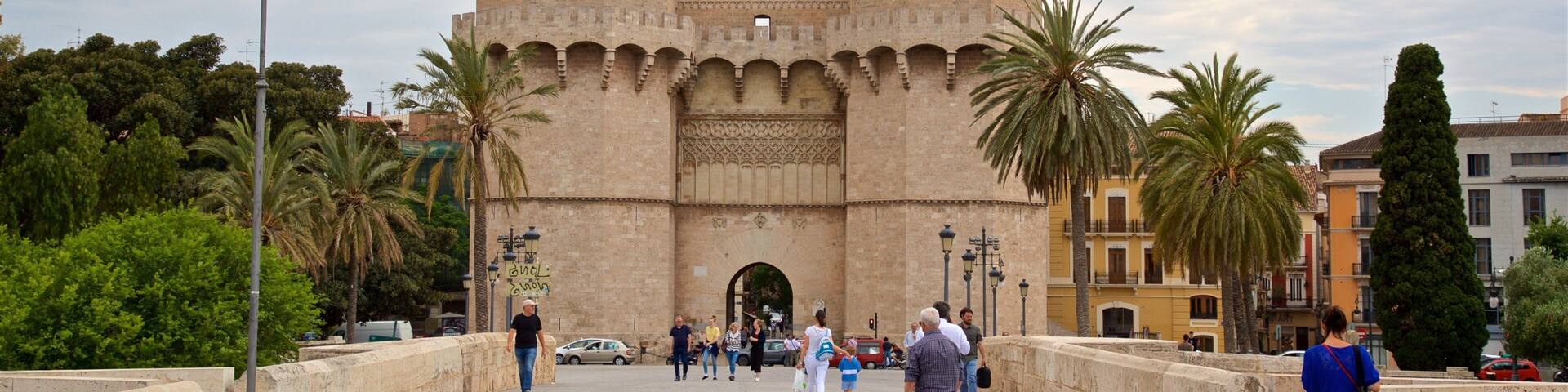 Serranos Towers showing a castle and heritage architecture as well as a small group of people