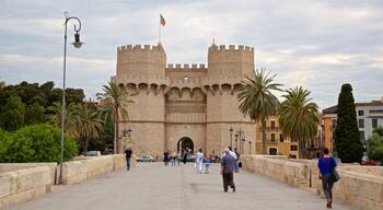 Serranos Towers showing a castle and heritage architecture as well as a small group of people