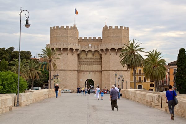 Serranos Towers showing a castle and heritage architecture as well as a small group of people