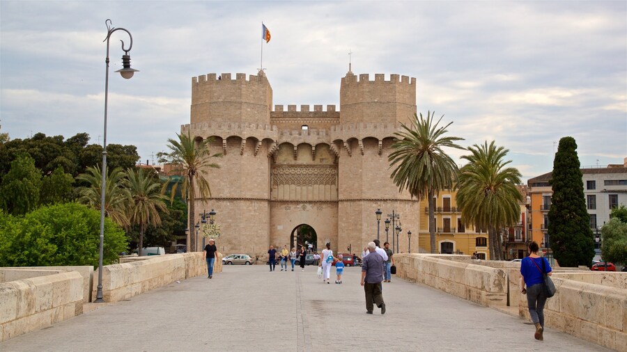 Serranos Towers showing a castle and heritage architecture as well as a small group of people
