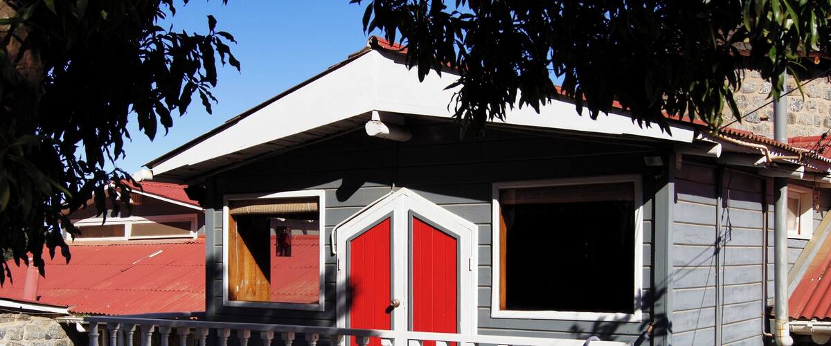 A house with a red door, a balcony, and a red roof.