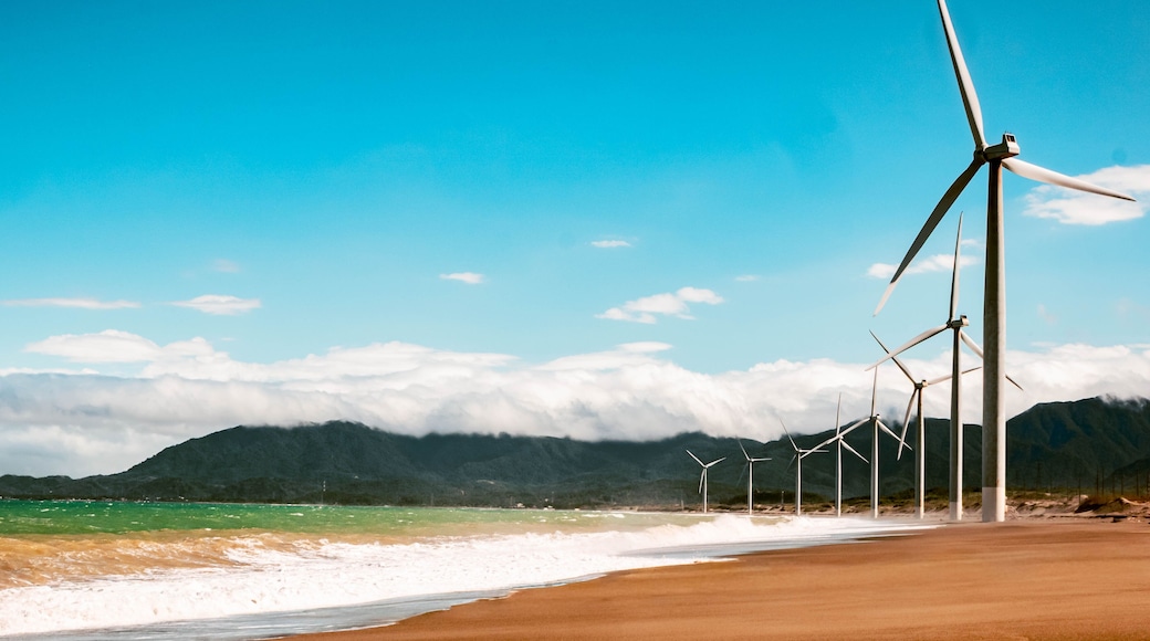 Aerial view of Bangui Wind Farm windmills along the coast of Ilocos Norte, Philippines at sunset.